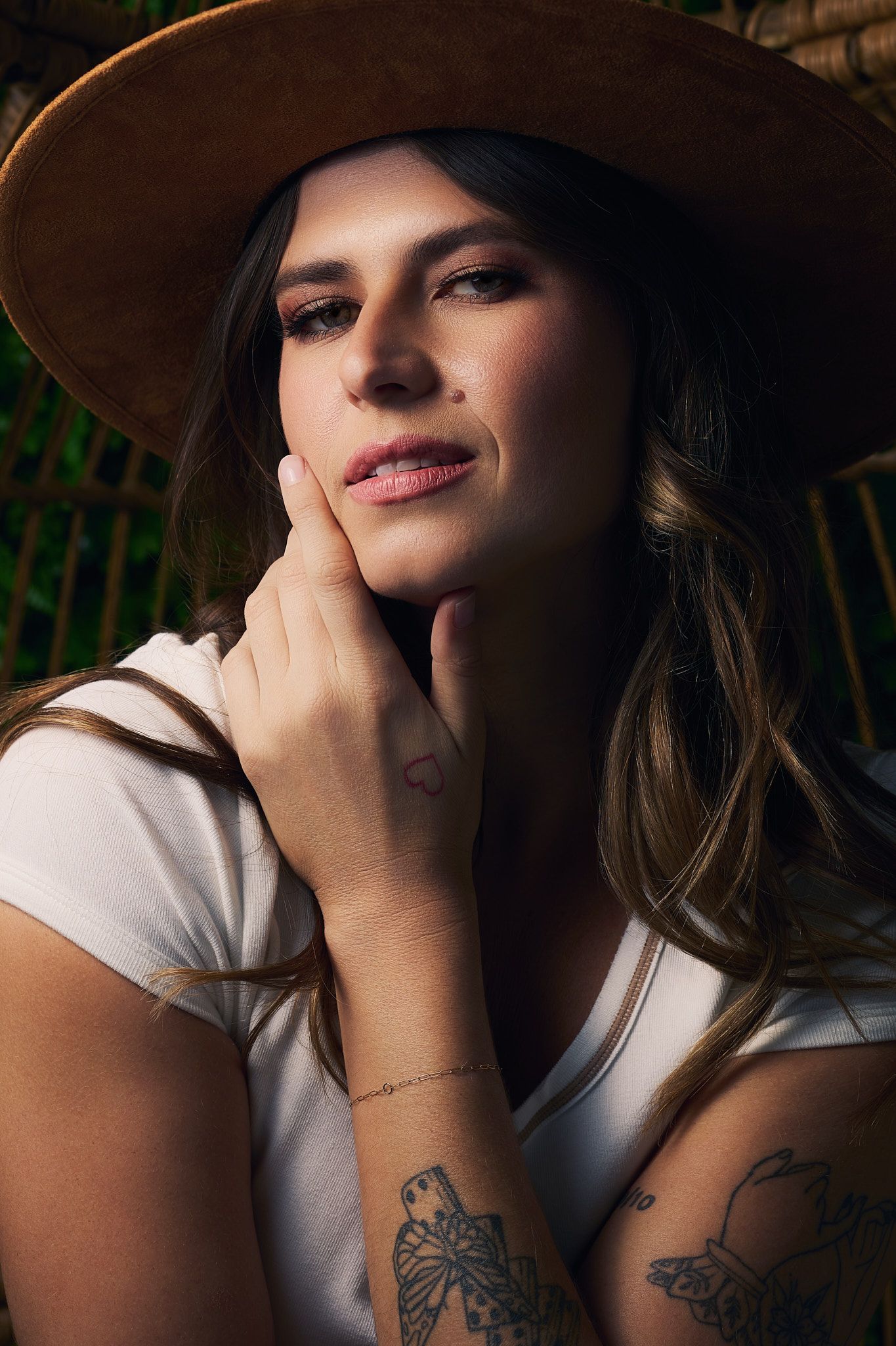 Artistic portrait series showing close-up shots in moody lighting with tattoo details and dramatic shadows.