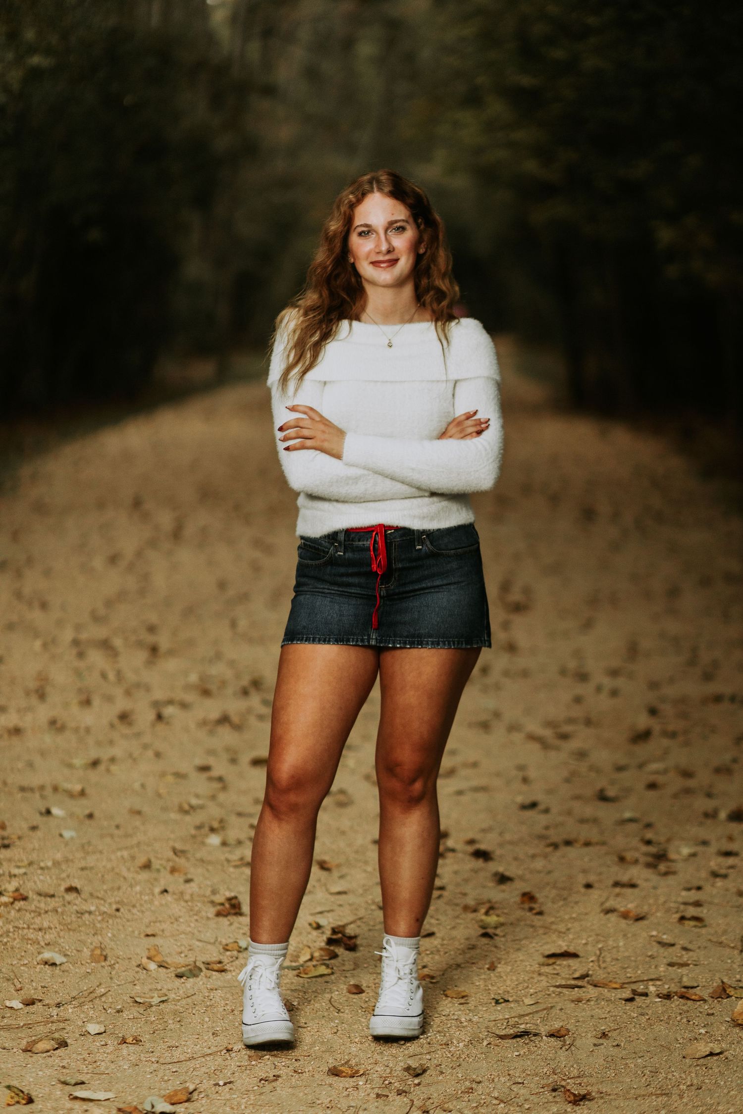 A series of cropped photos showing someone wearing jean shorts and a white sweater standing on fallen autumn leaves.
