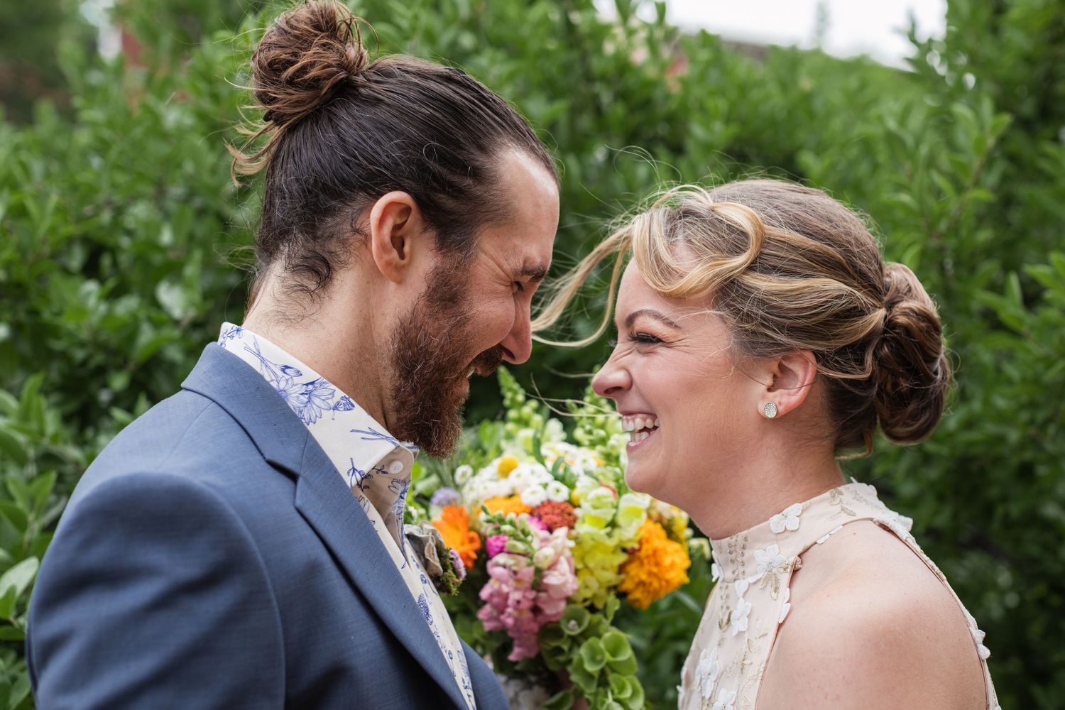 Couple sharing joyful moments in a garden setting with colorful flowers.