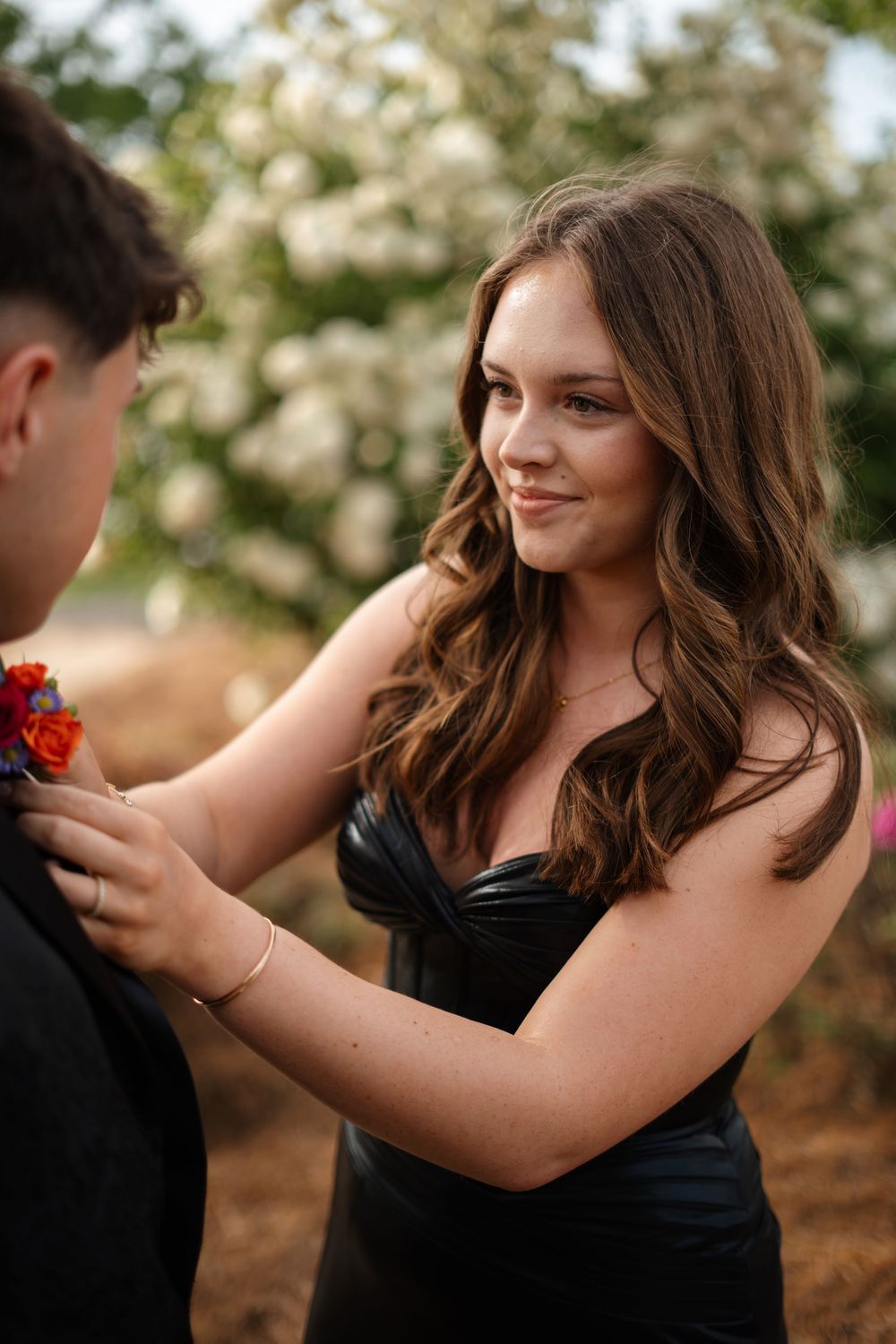 A romantic photoshoot in a garden setting with black formal attire.