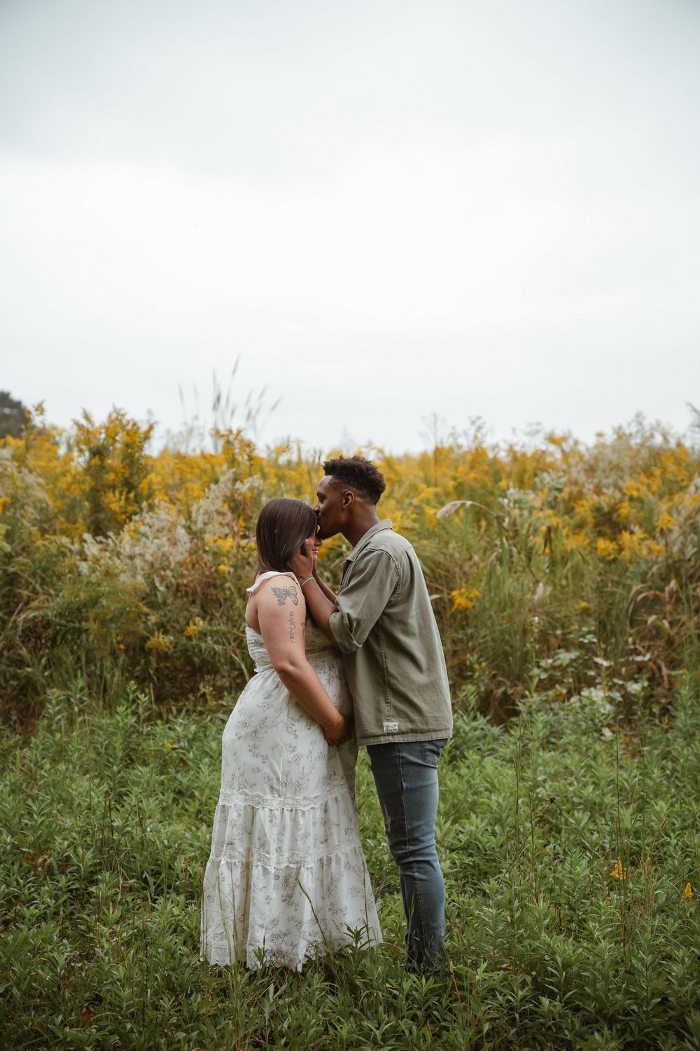 Couple sharing intimate moments in a wildflower field during a photo session.