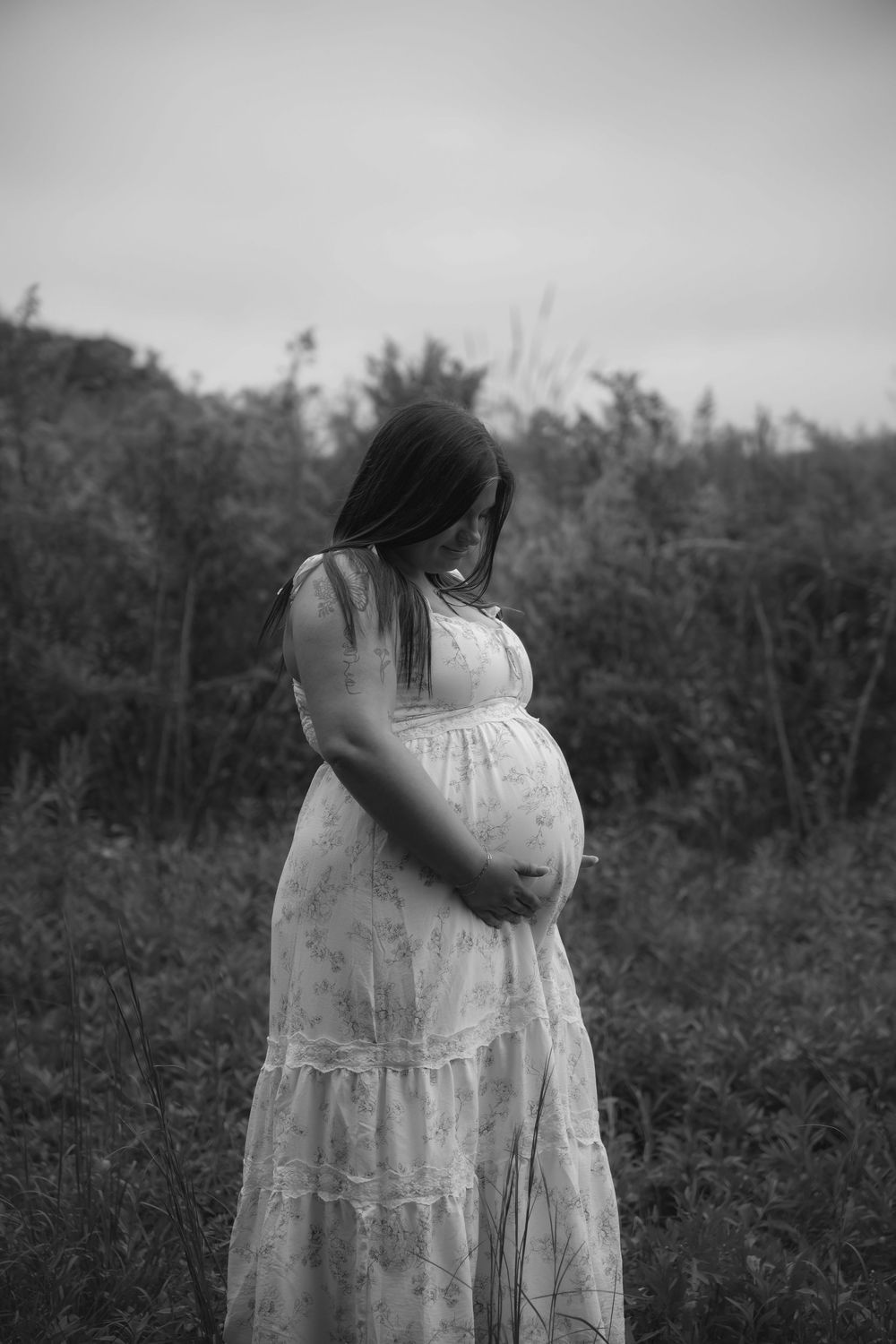 Black and white artistic portrait in a natural outdoor setting.