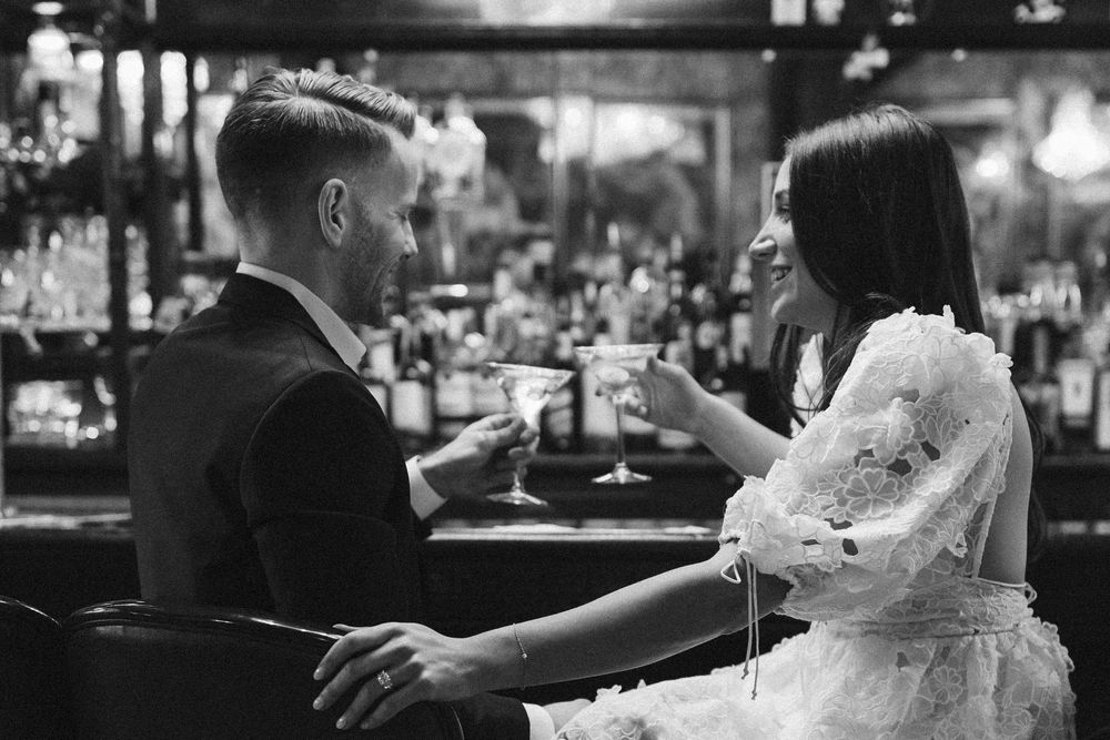 Couple enjoying cocktails at an elegant bar counter.