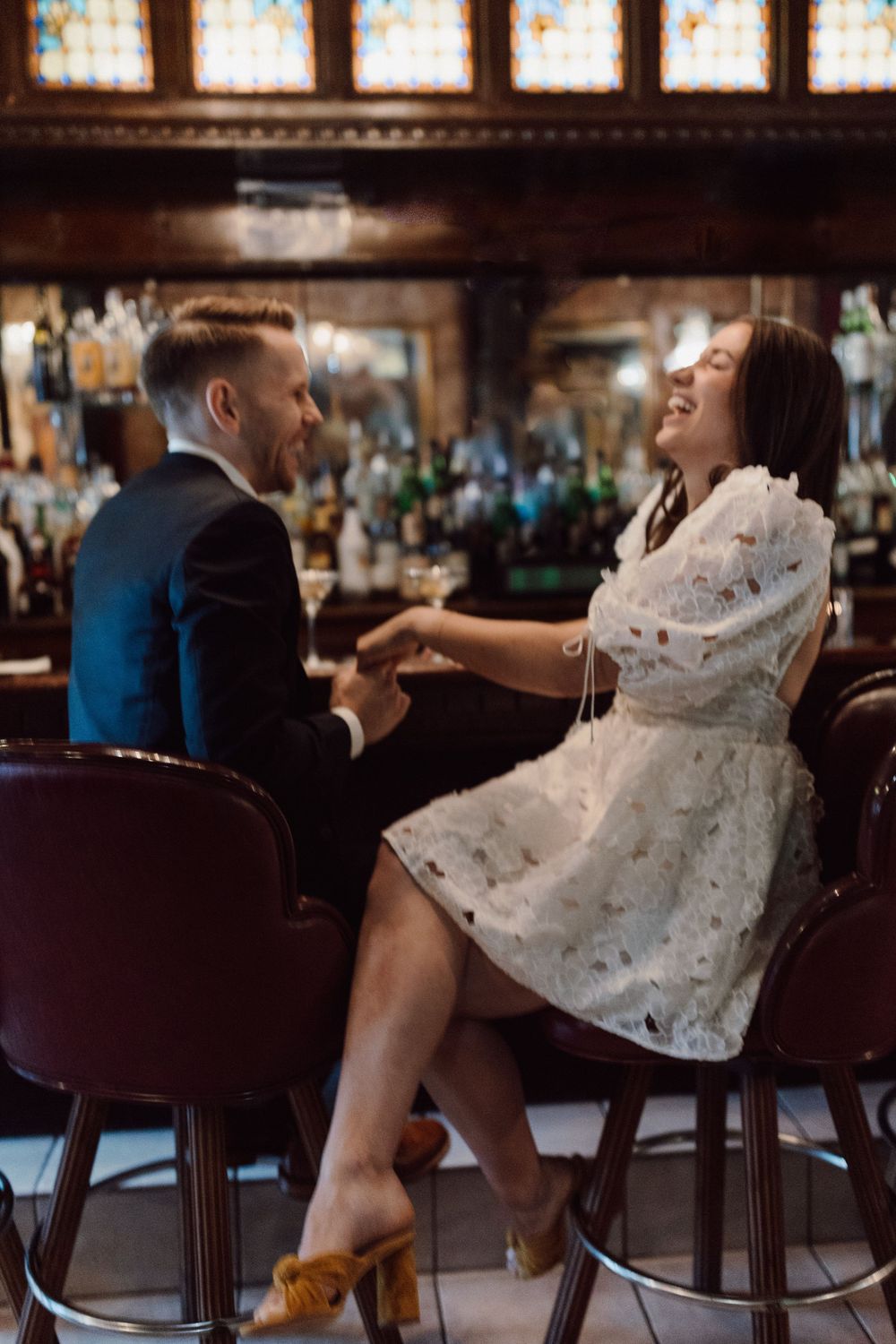 Couple in formal attire sharing intimate moments at a bar.