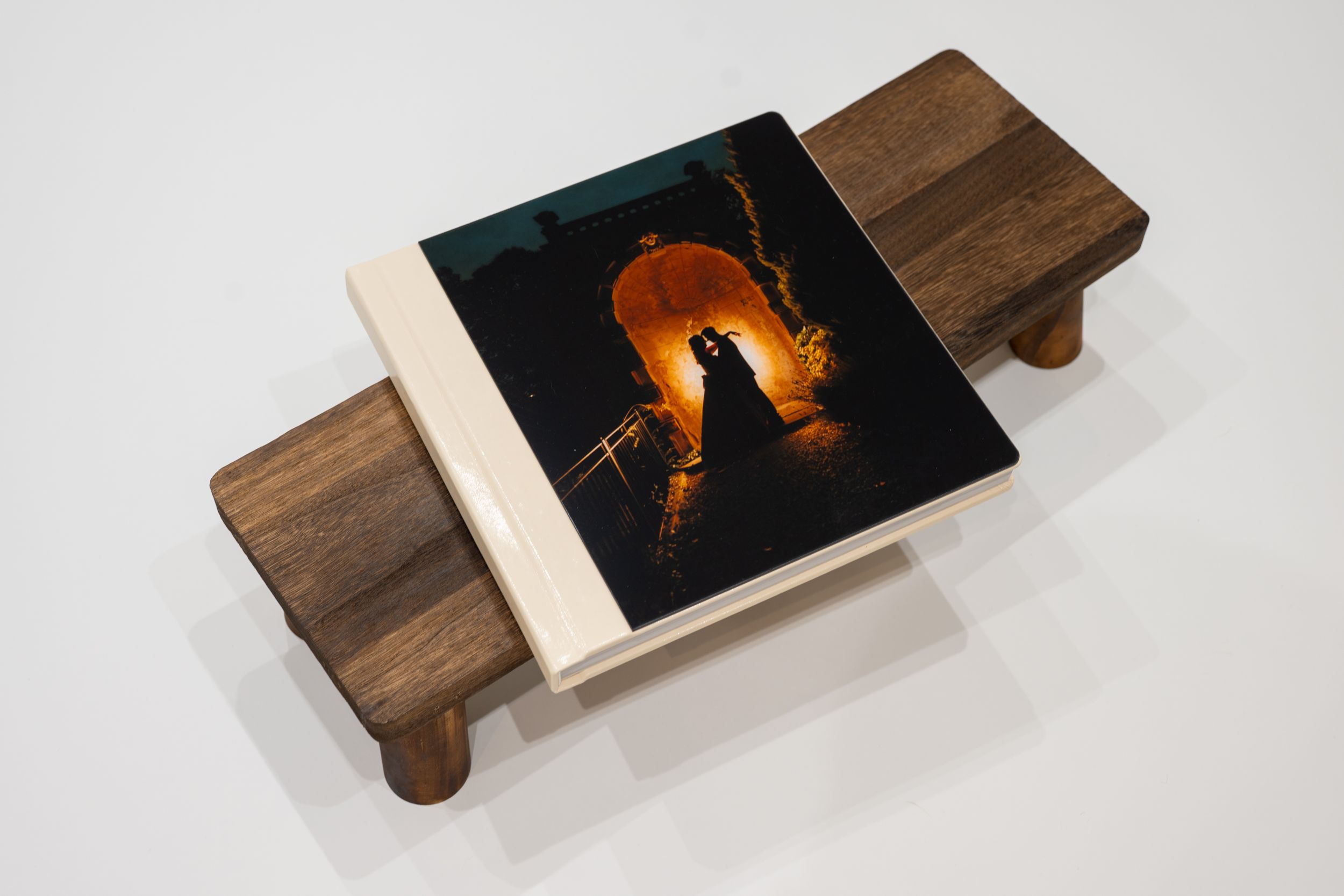 Four photos showing a wooden serving board with a dark photograph embedded in its surface displaying a sunset silhouette.