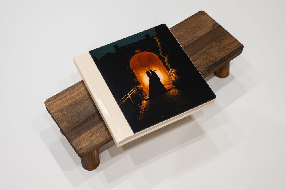 Four photos showing a wooden serving board with a dark photograph embedded in its surface displaying a sunset silhouette.