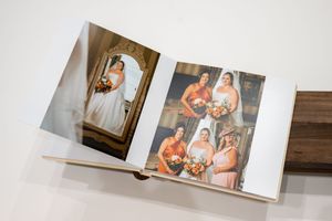 Wedding photo album displaying a bridal portrait and group shot with bridesmaids in peach dresses holding bouquets.