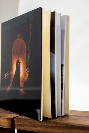 A series of dark art photographs displayed in an open book showing shadowy figures illuminated by orange light.