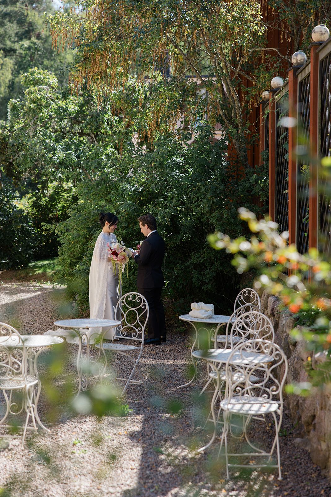 Romantic garden setting with white wrought iron furniture and lush greenery creating an intimate outdoor space.