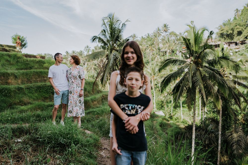 Bali Family photoshoot in a lush tropical garden with palm trees and greenery.