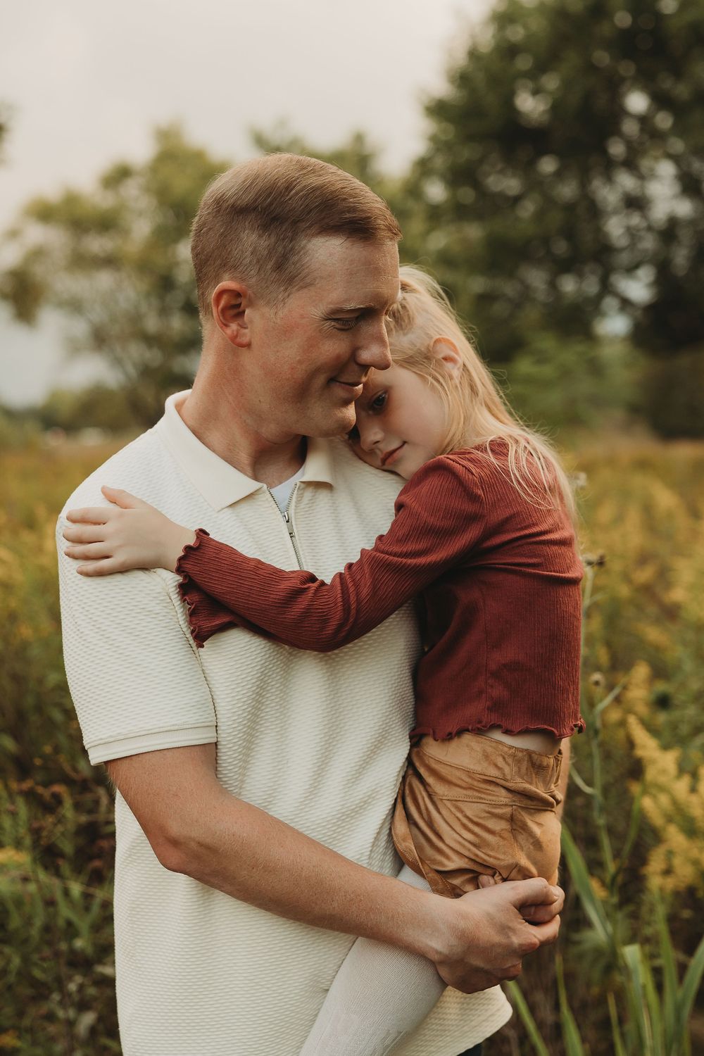 A tender moment between parent and child embracing outdoors in a natural setting during golden hour.