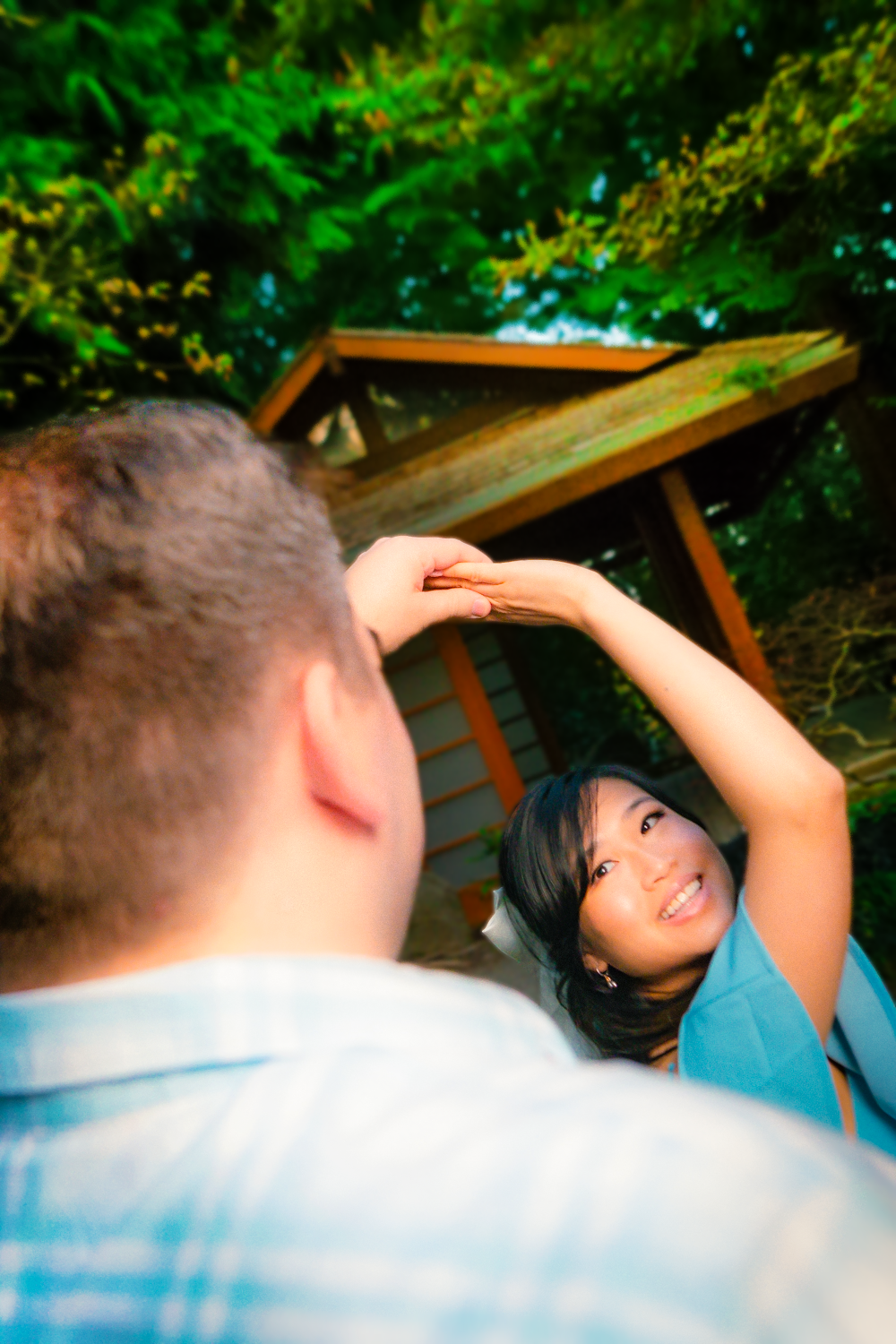 Couple sharing a romantic moment together in a lush green garden setting.