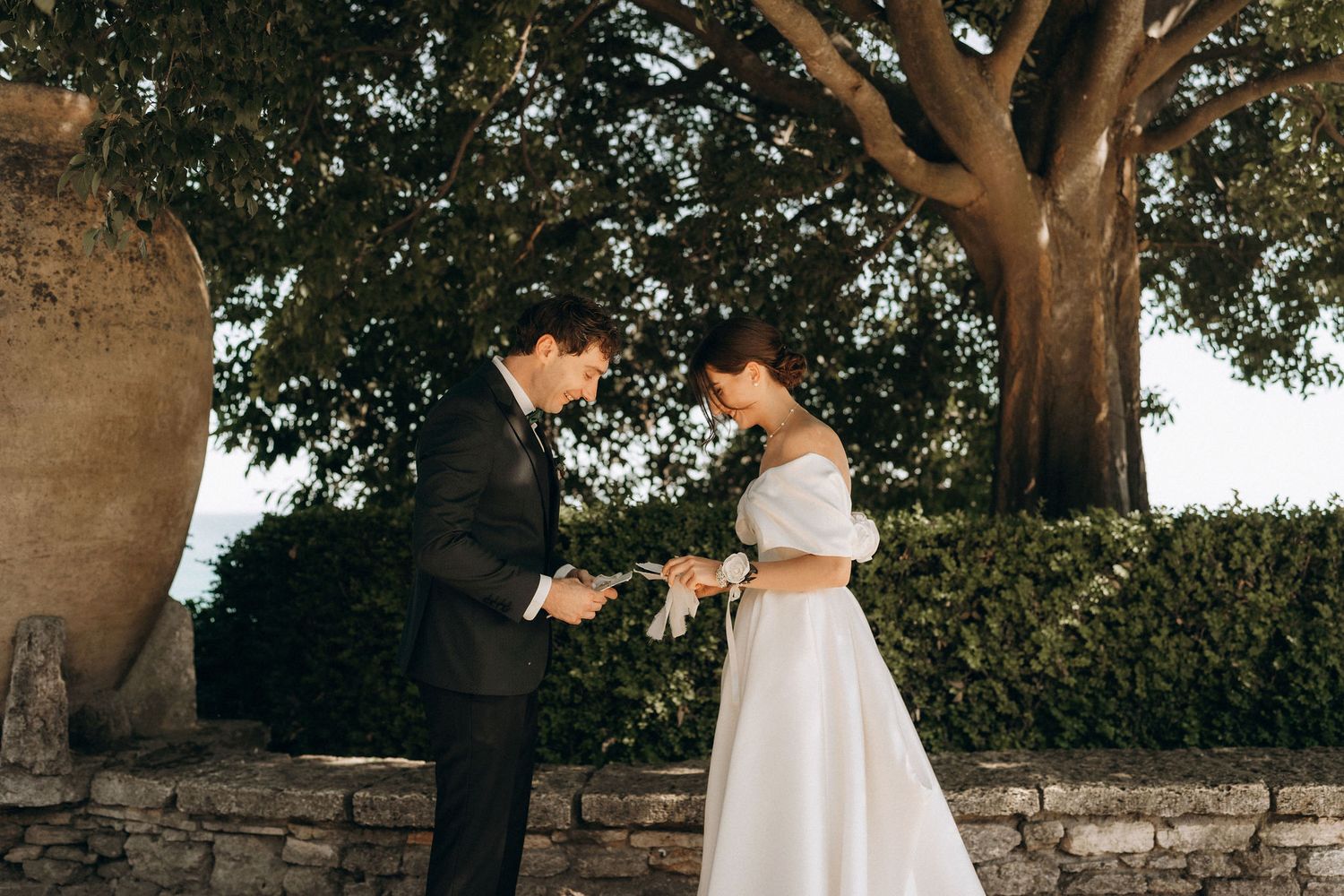 Wedding ceremony location featuring stone walls and overhanging trees in natural light.