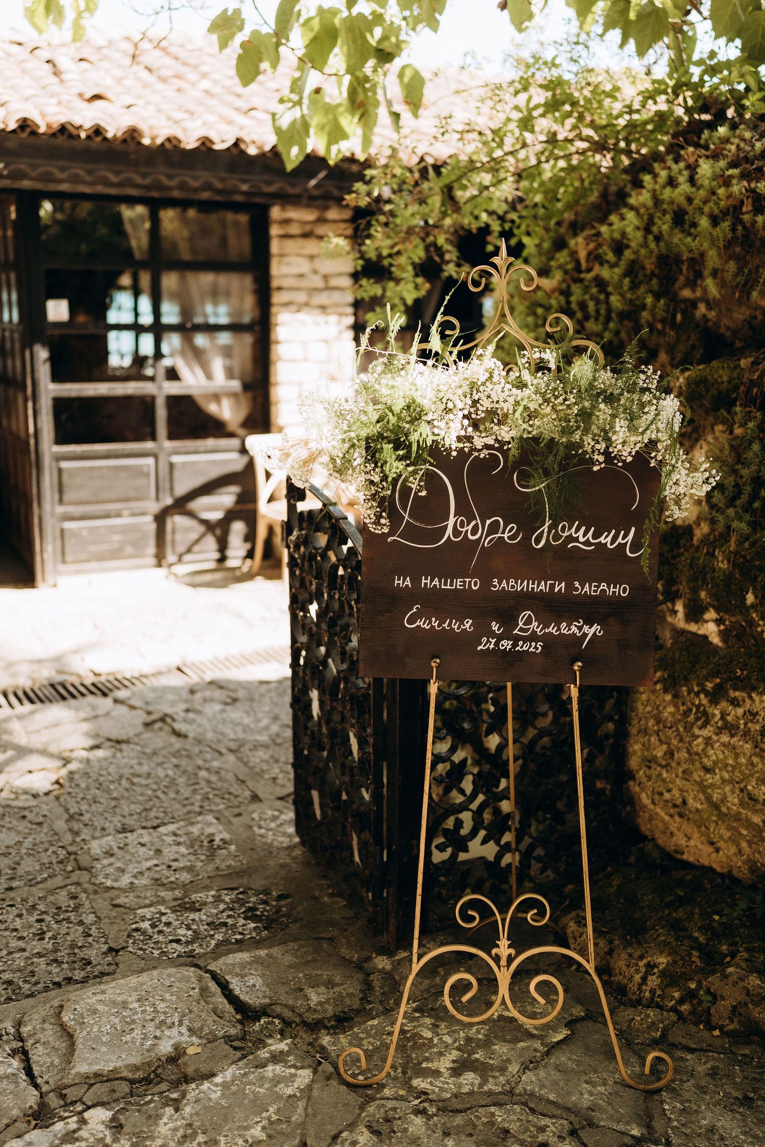 Rustic wooden wedding signs with elegant calligraphy displayed in an outdoor garden setting.