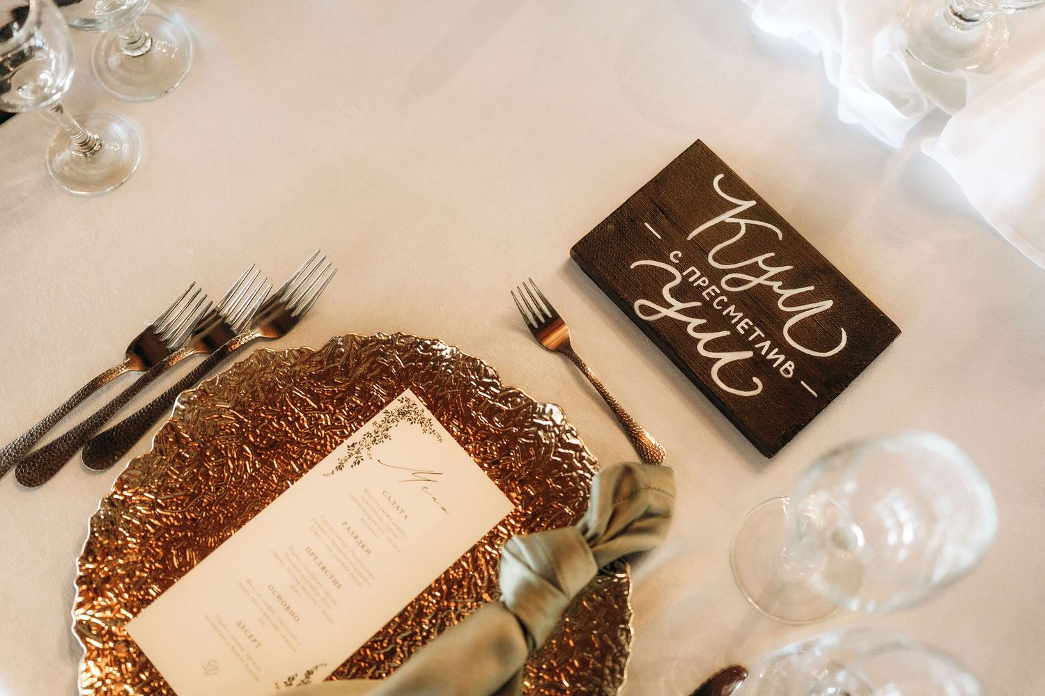 Wedding place settings with copper charger plates and elegant black menu cards.