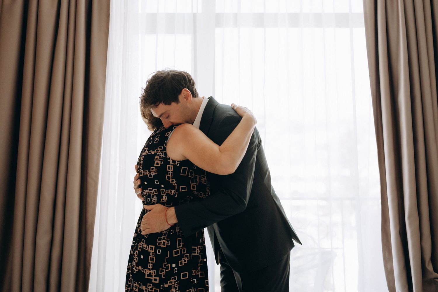 Elegant getting ready moments captured in a hotel room with soft window light.