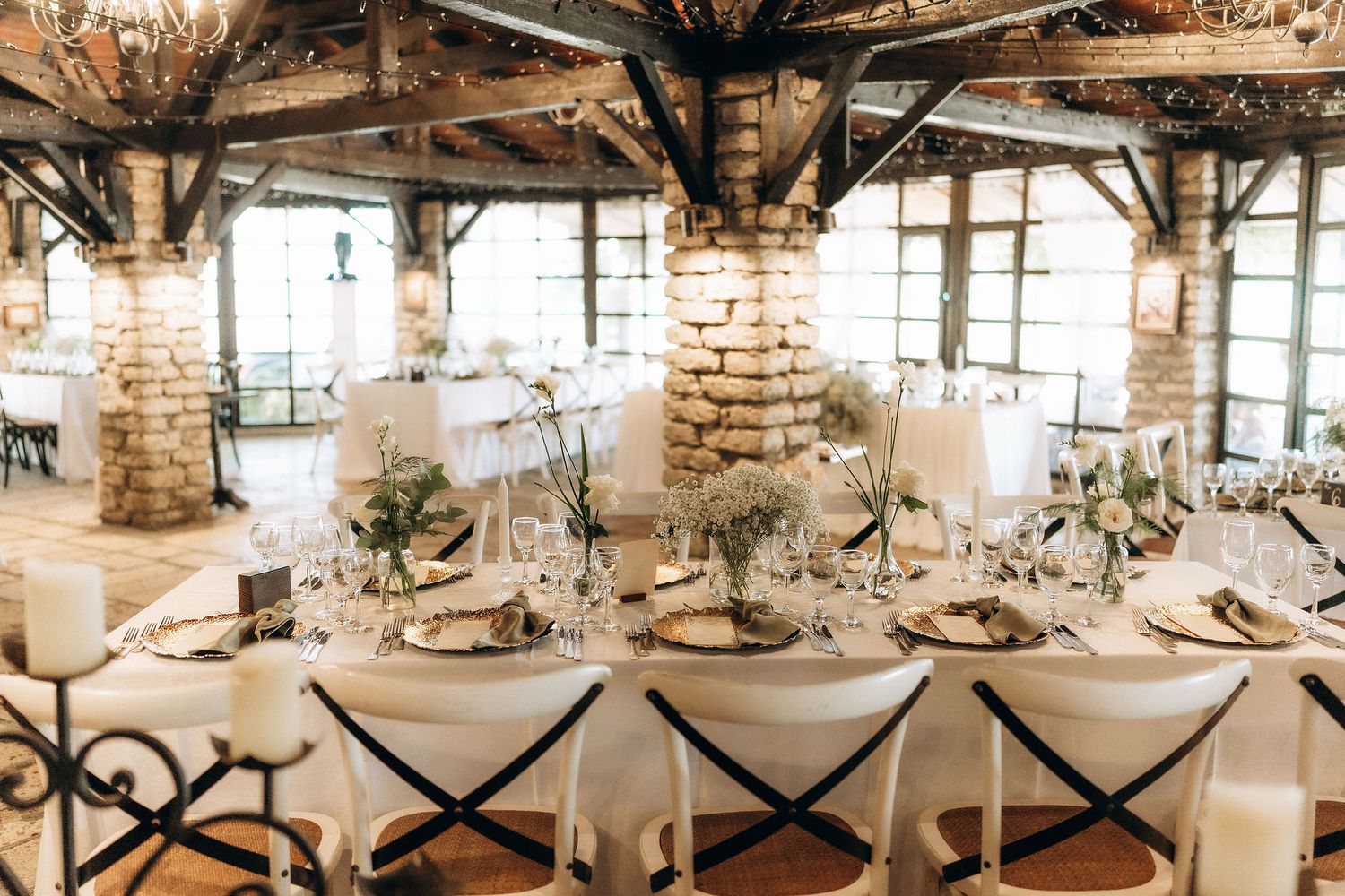 Panoramic view of an elegant wedding reception setup in a rustic barn venue.