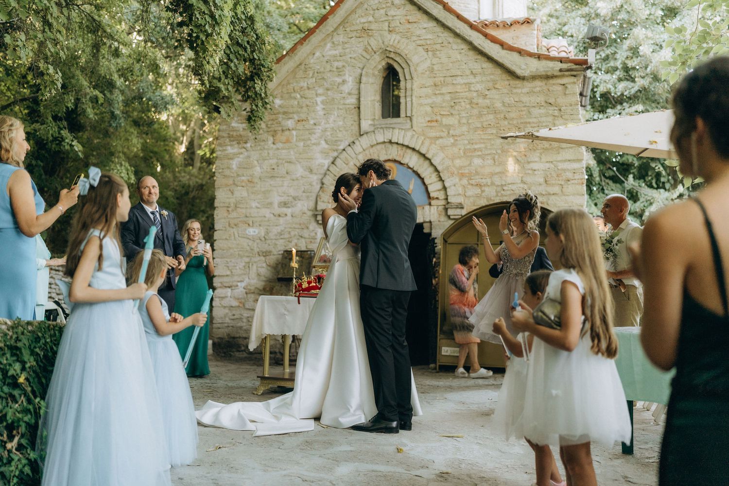 Wedding celebration in progress at a beautiful stone venue with natural greenery.