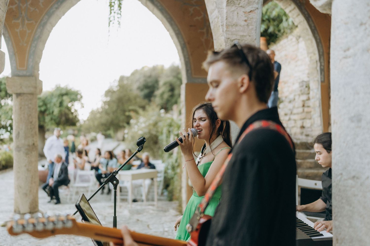 Wedding reception with musicians performing under stone archways.