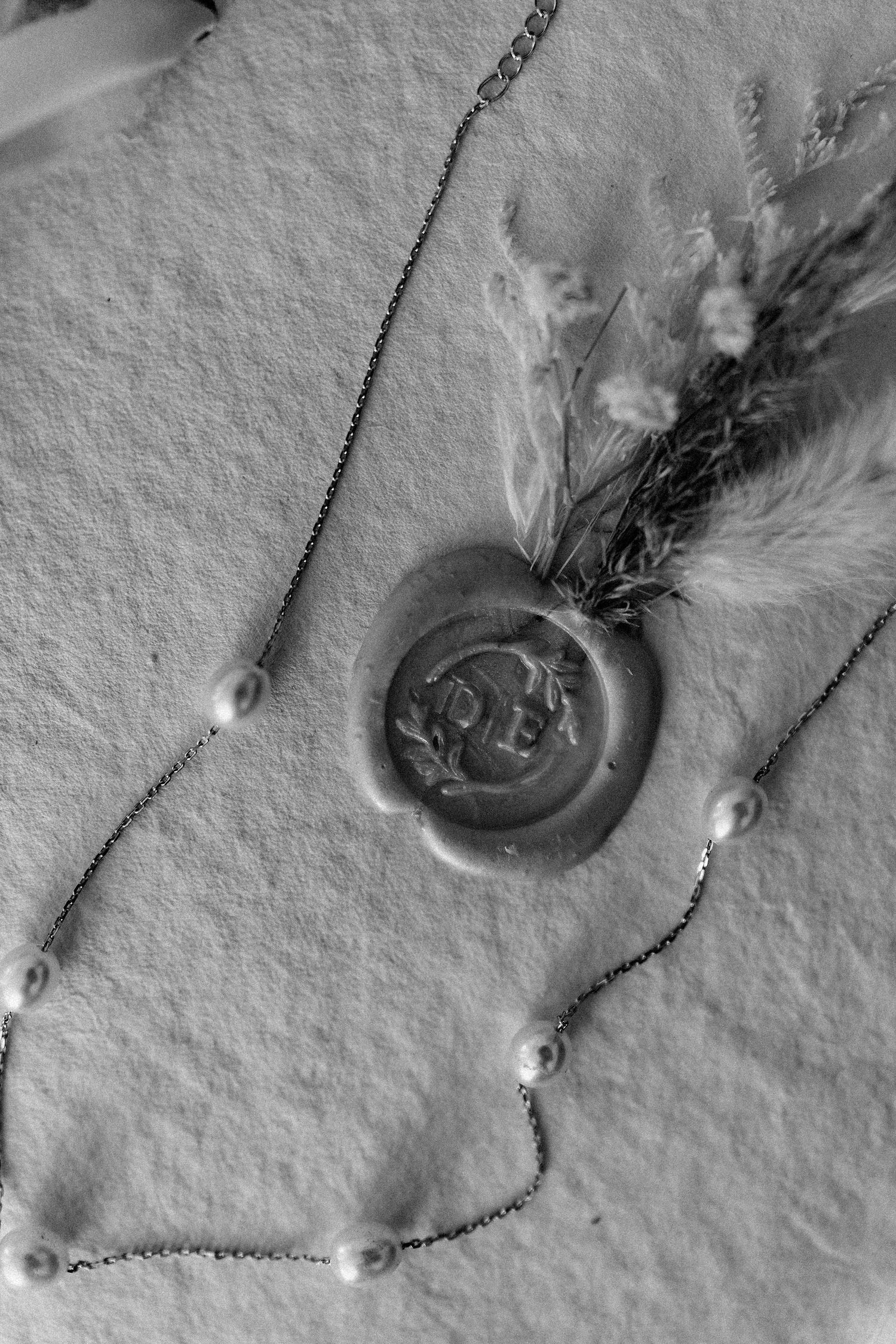 Artistic black and white macro shots of jewelry details on textured paper.