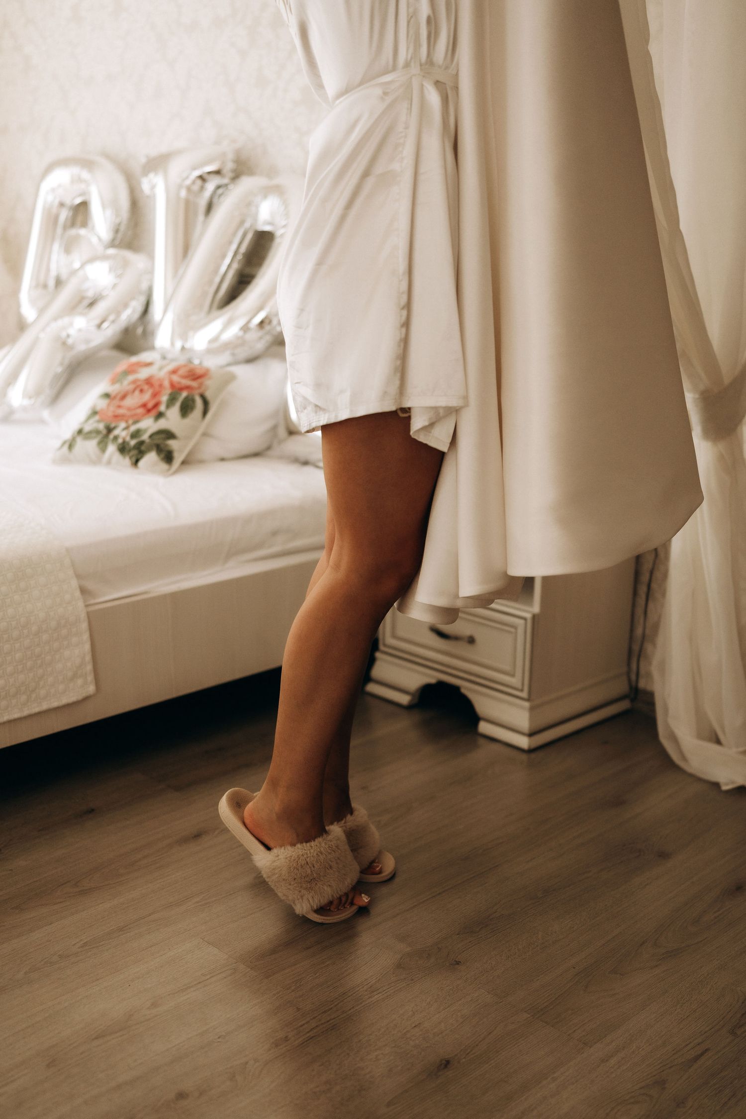 Detail shots of bridal shoes and dress hem against wooden flooring.