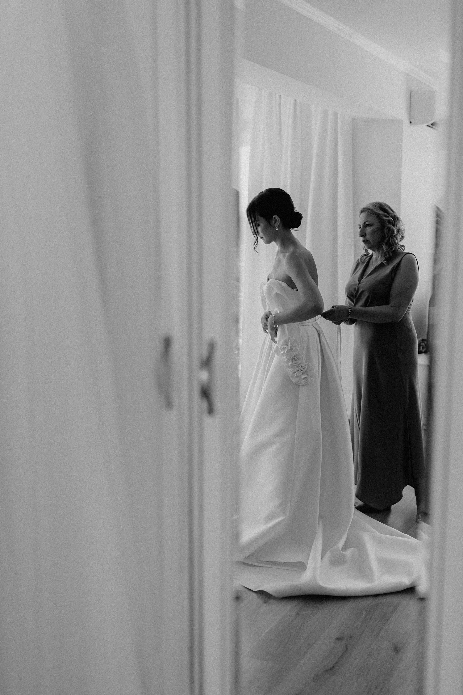 Silhouettes of wedding dress fitting and preparation in a bright minimalist space.