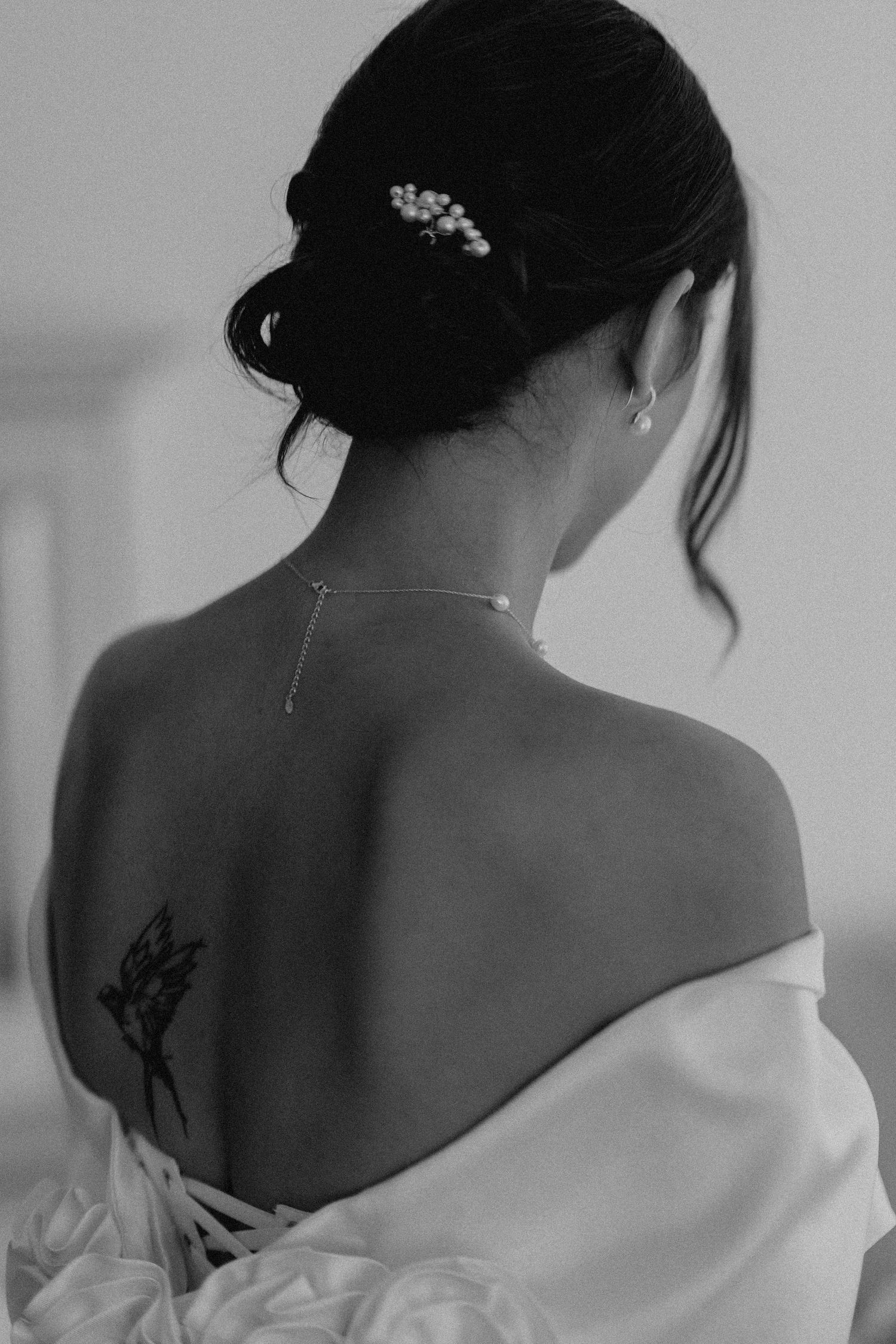 Artistic black and white shots showing details of a bride's back and tattoo.