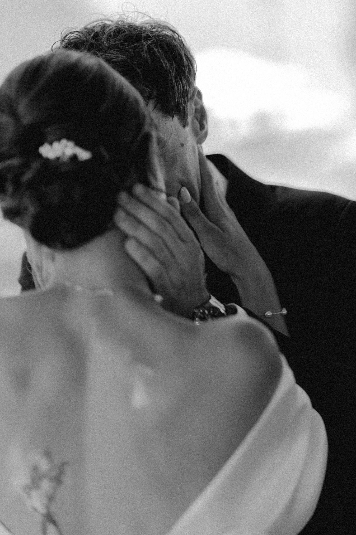 Black and white close-up of a romantic wedding moment outdoors.