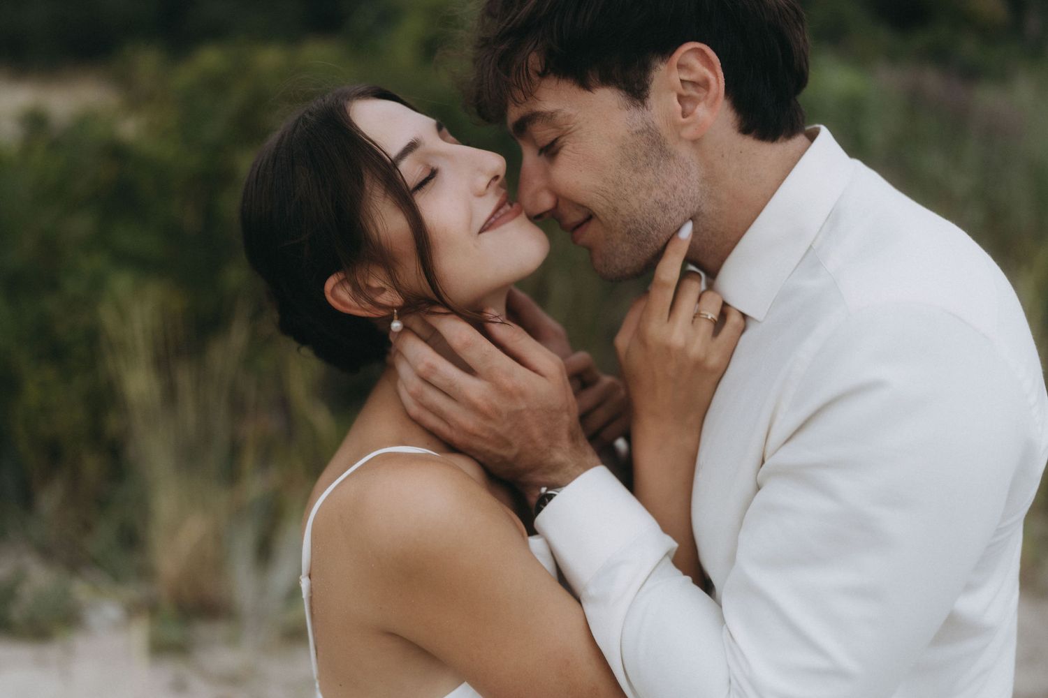 Close-up romantic moment captured between couple during beach photoshoot.