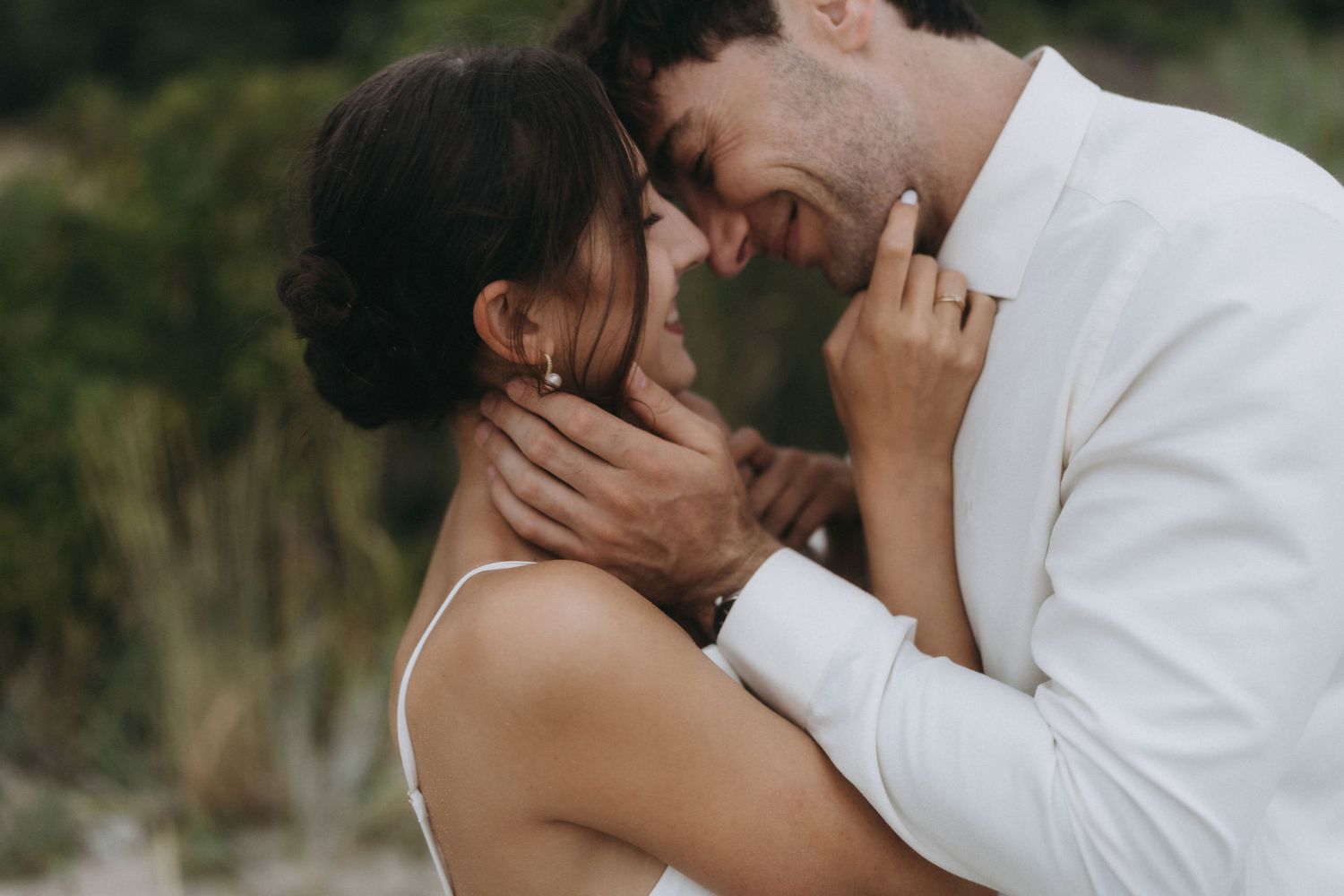 Tender moment between couple during coastal engagement photography session.