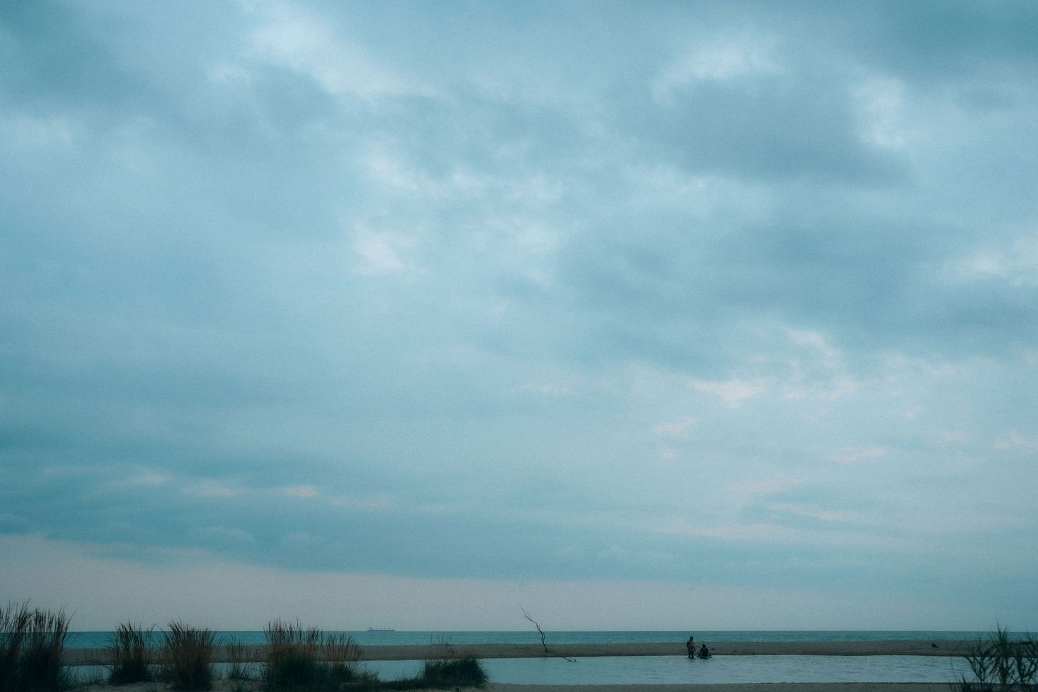Panoramic view of cloudy beach landscape with turquoise waters.