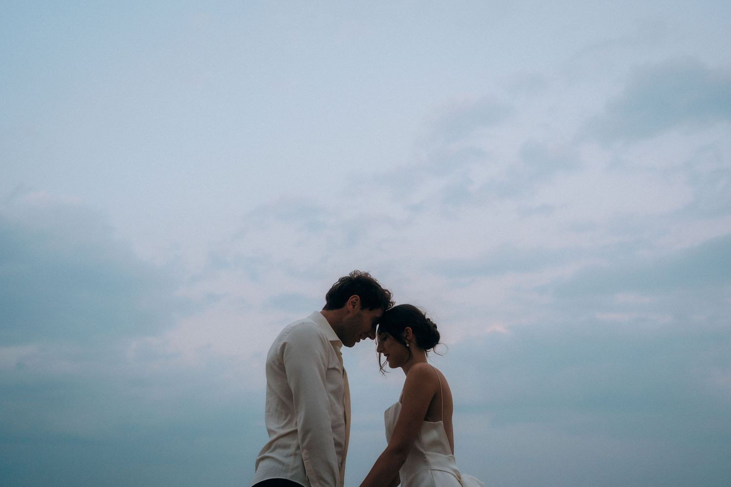 A romantic beach photoshoot with soft lighting and crashing waves in the background.