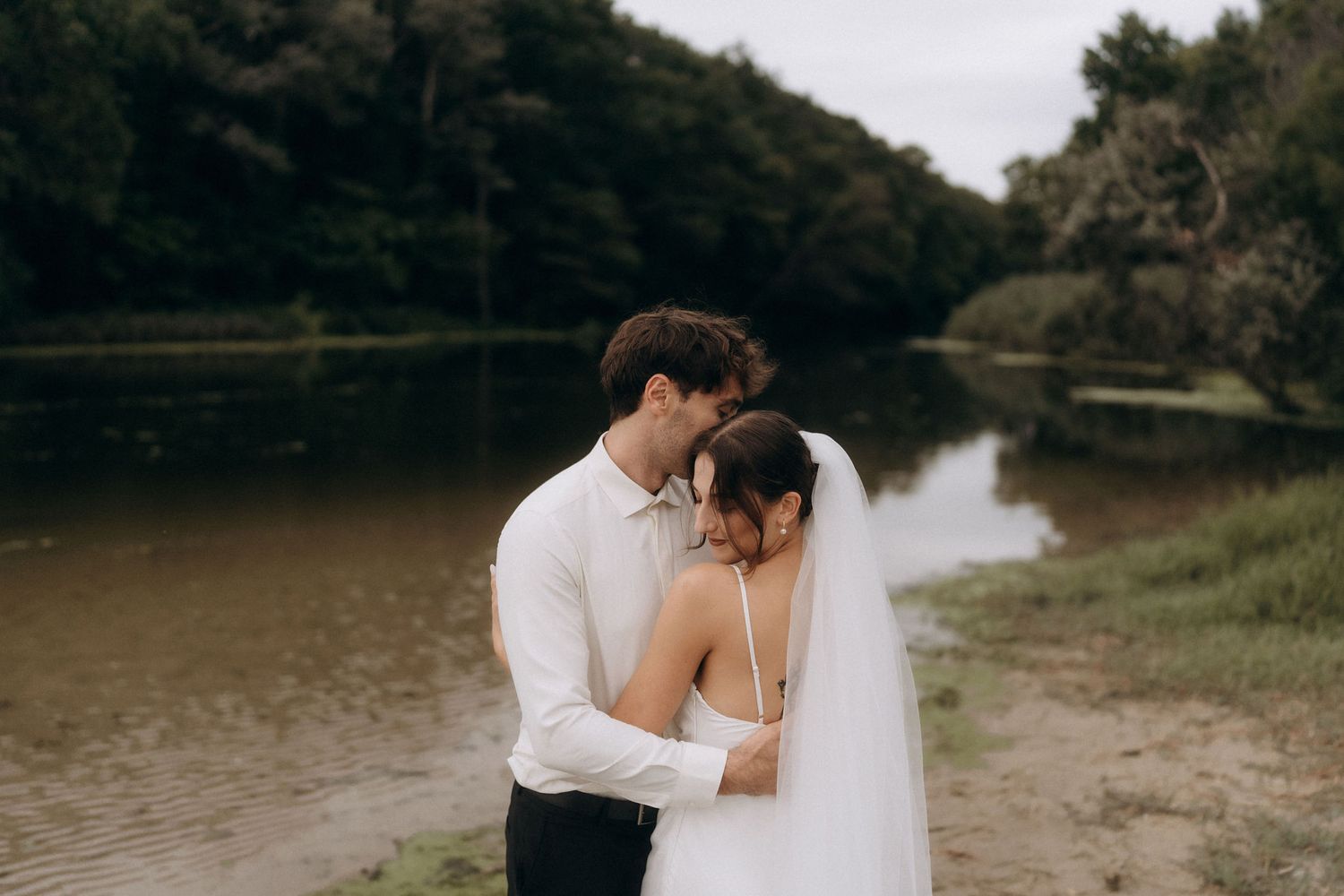 Candid wedding moments captured along a peaceful lakeshore.