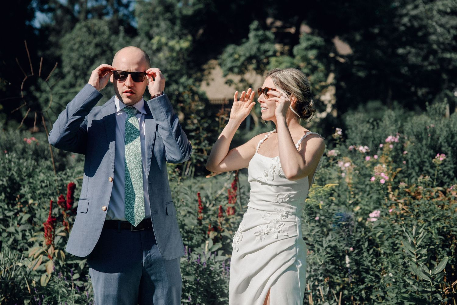 Couple shares romantic moments in a lush garden setting with vibrant wildflowers and greenery.
