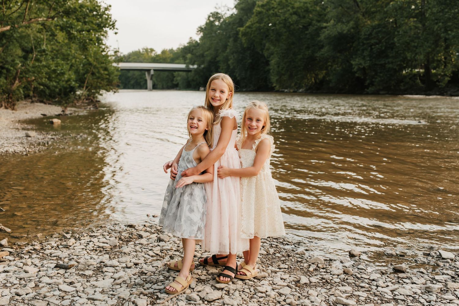 Sisters play together in the river during their summer mini session in Cincinnati.