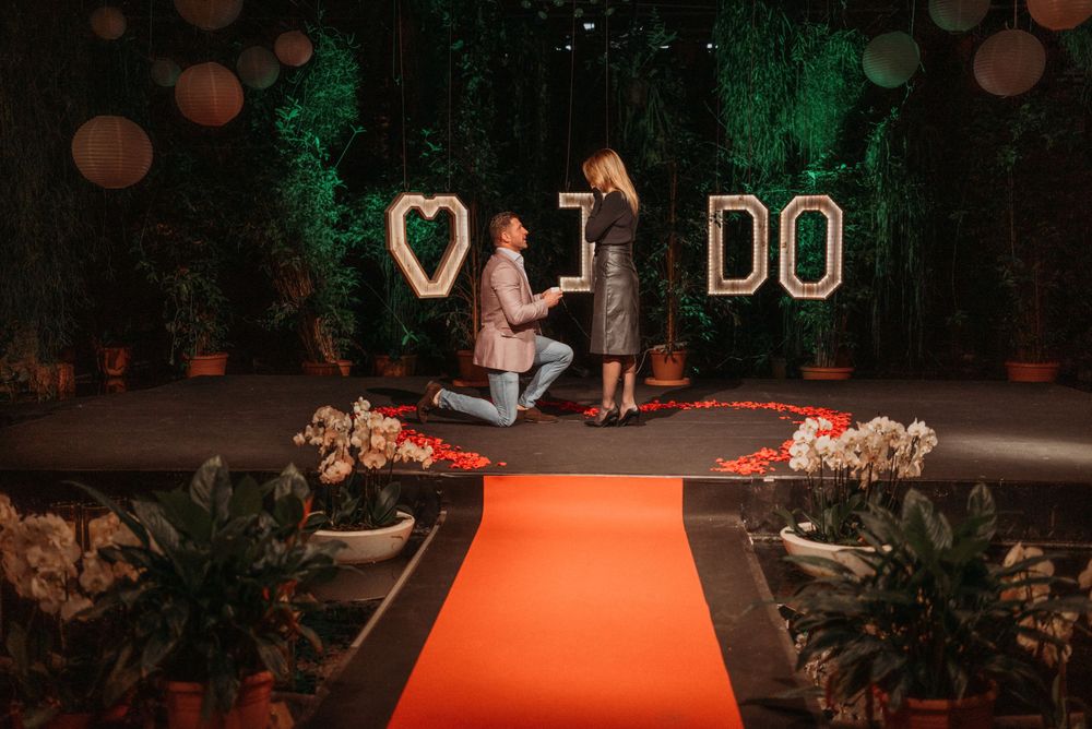 Wedding venue decorated with romantic lighting and a heart-shaped 'I DO' sign.