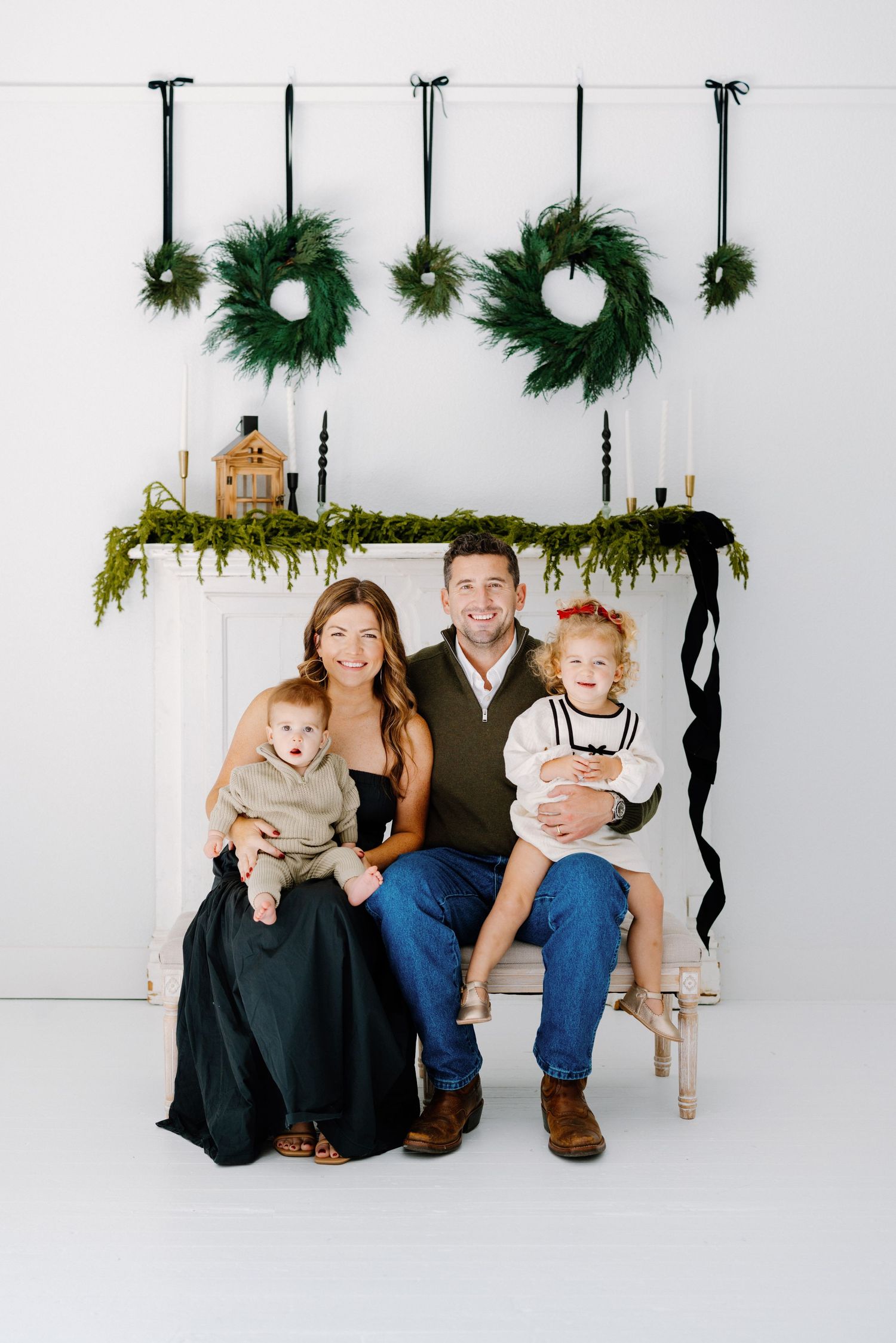 Holiday portrait setting with evergreen wreaths and garland decorations on white background.