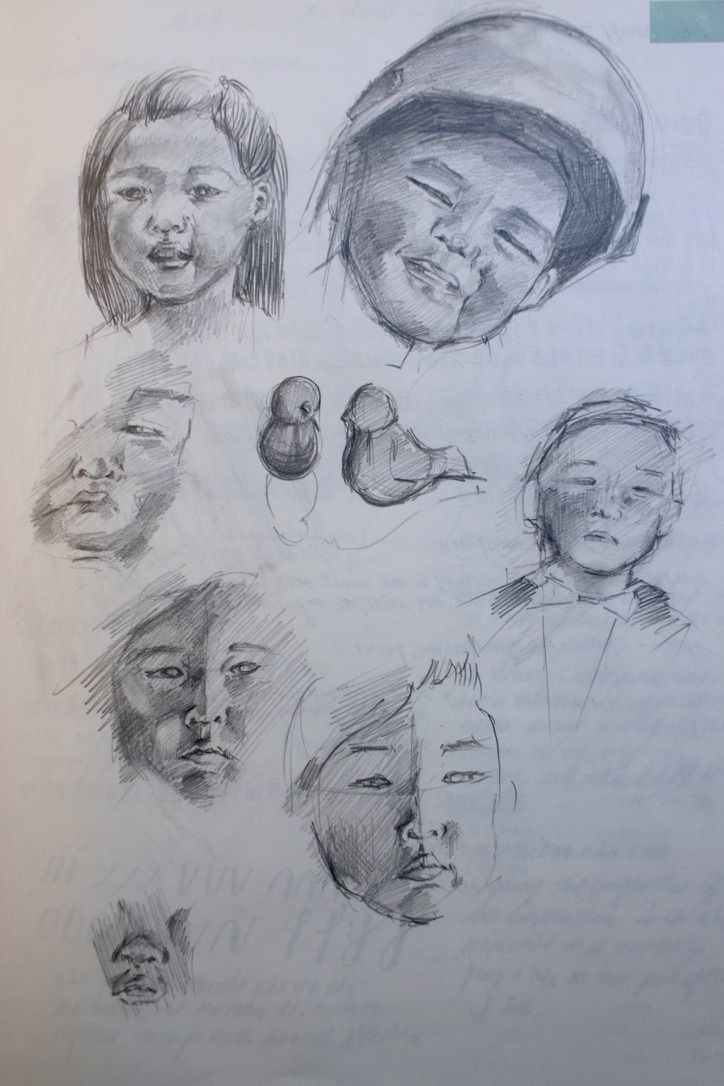 A pencil sketch page showing multiple facial expression studies and two small bird drawings.
