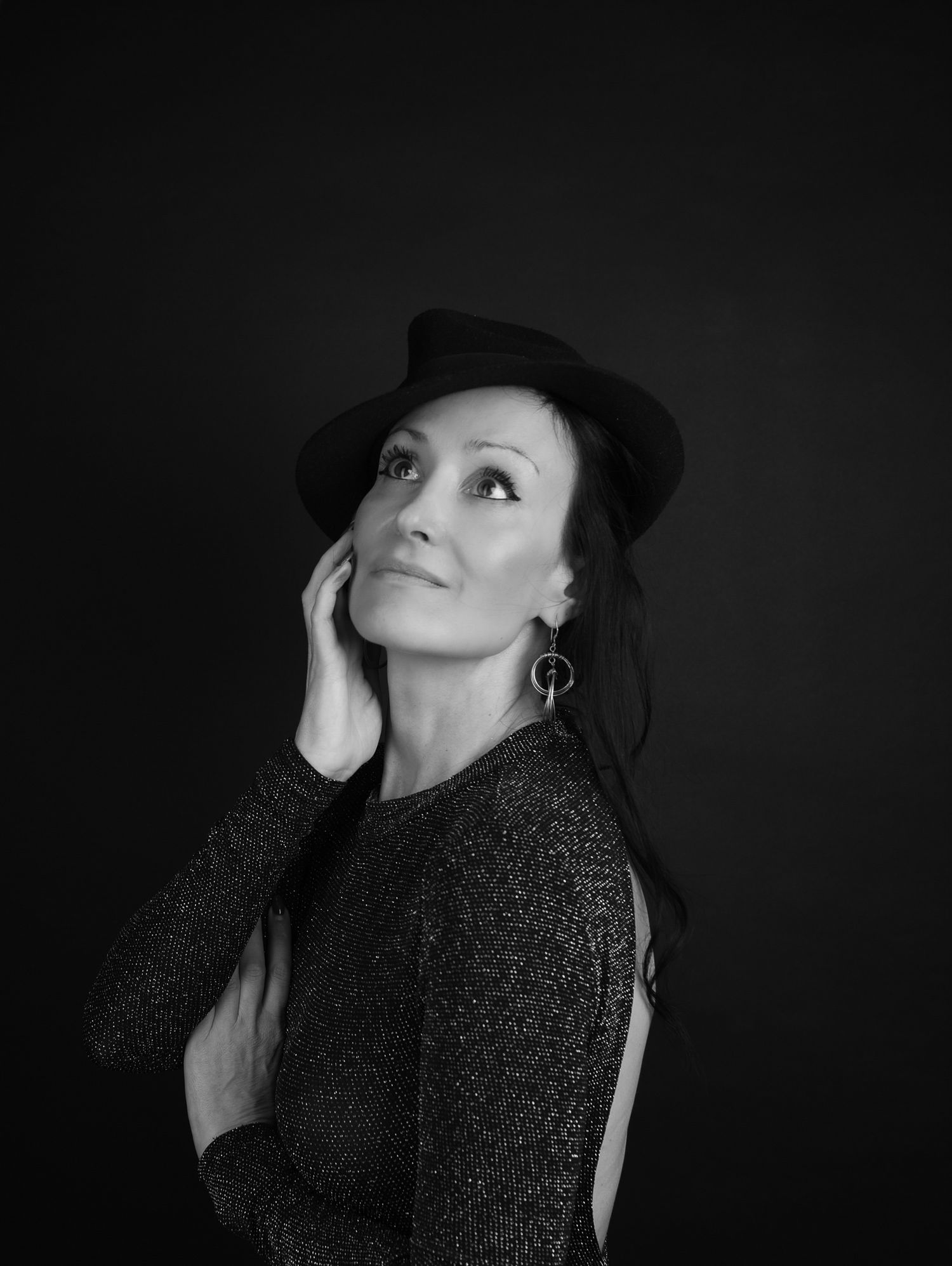Fine Art Fotografie, Artistic black and white portrait of woman in hat and sparkly top looking upward.