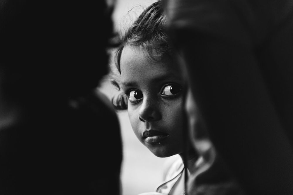 Intimate black and white portrait capturing a child’s thoughtful expression