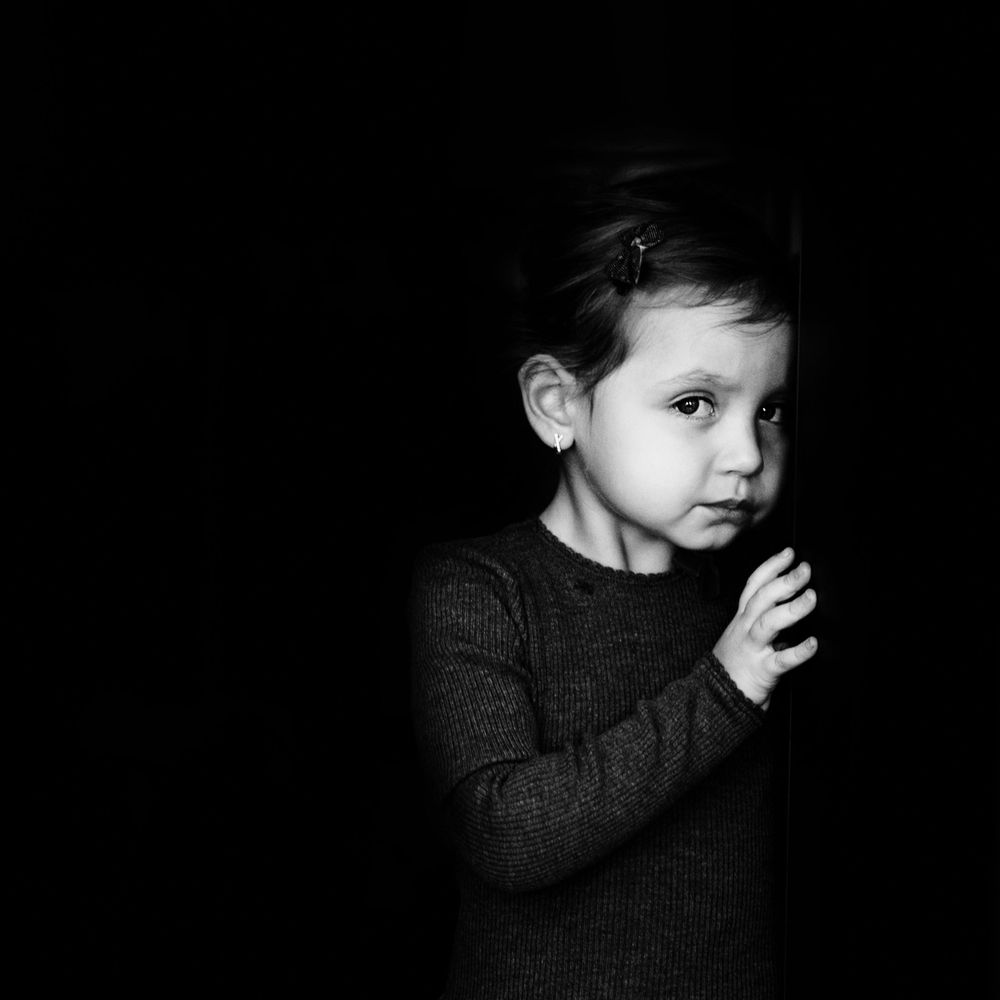Emotional black and white child portrait with expressive eyes and soft light