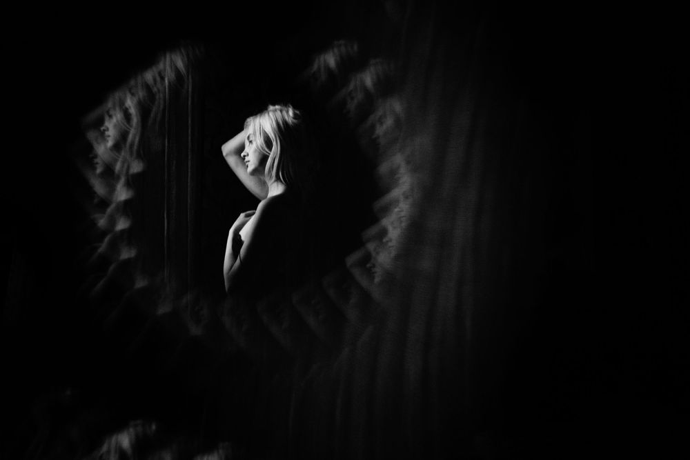 Conceptual black and white portrait with motion blur and layered emotion