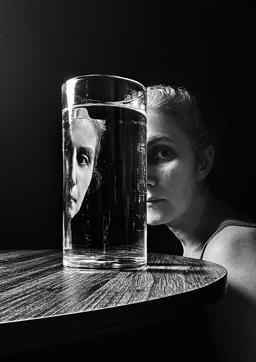 Surreal black and white fine art portrait with reflection in a glass of water