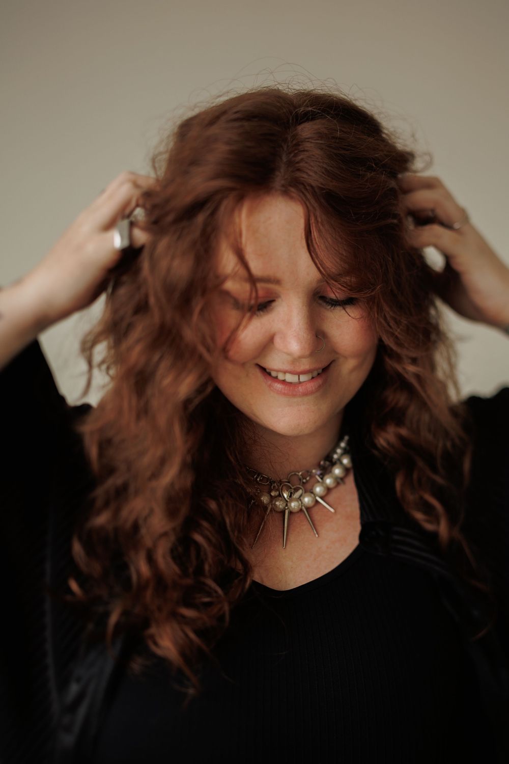 A series of expressive portraits showing movement of curly brown hair against a dark background with dramatic lighting.