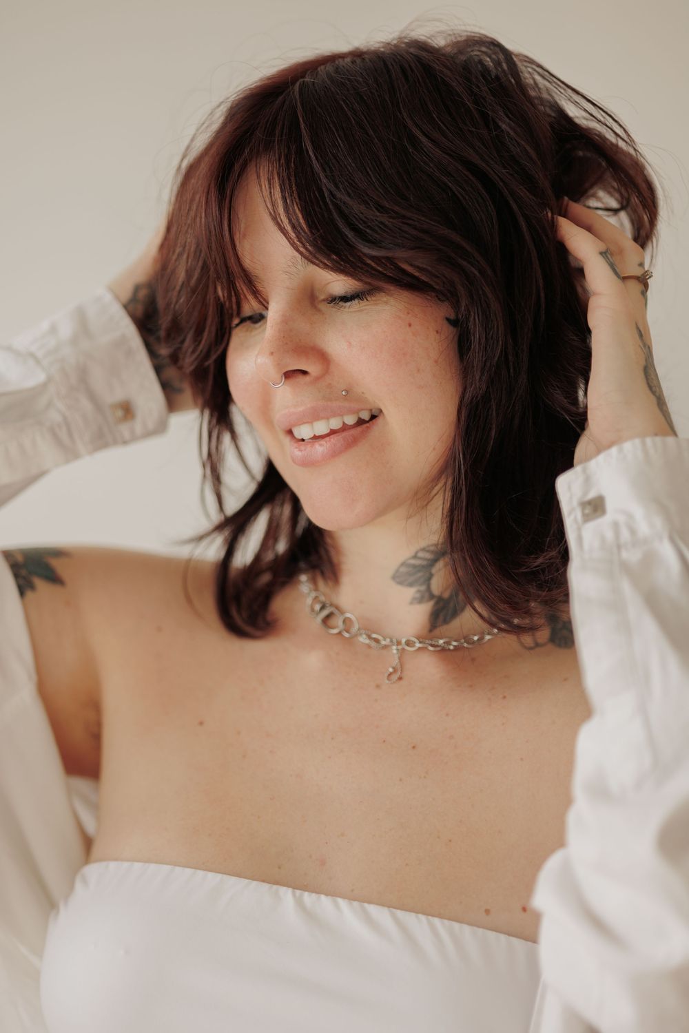 A series of soft, romantic photos showing a person with dark hair wearing a white top against light colored bedding.