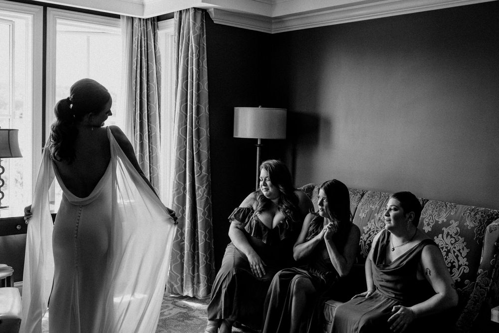 A dramatic black and white scene of a wedding dress reveal in a hotel room.