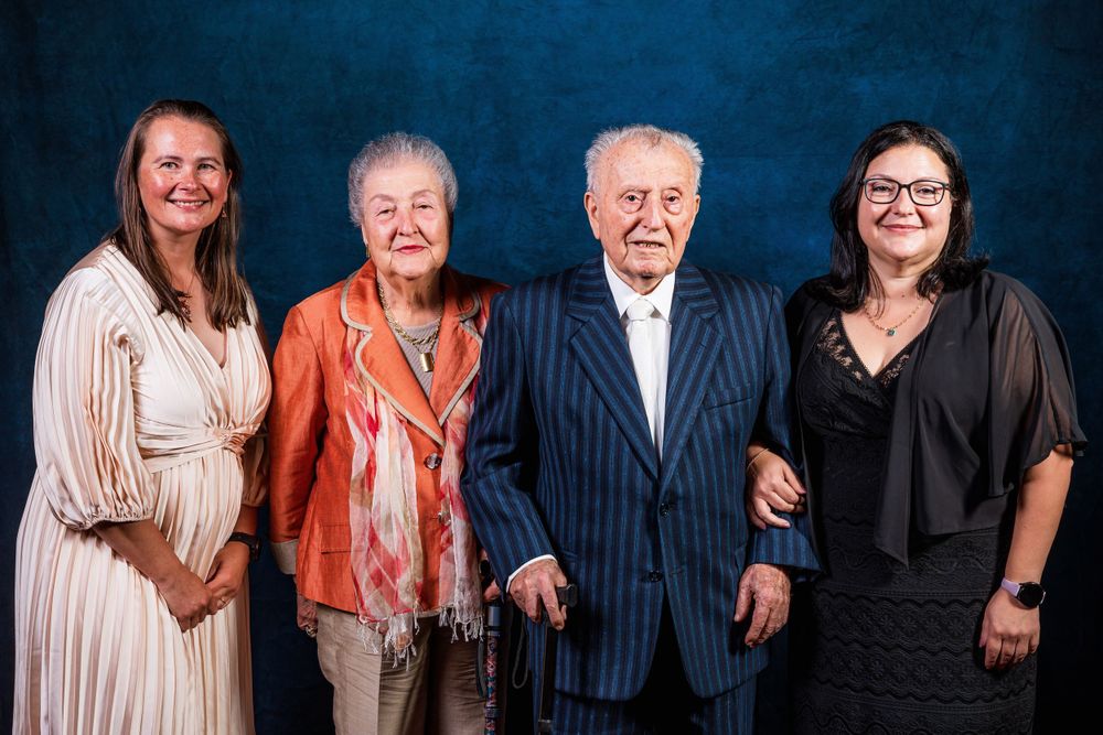 Group portrait against blue backdrop with business formal attire.