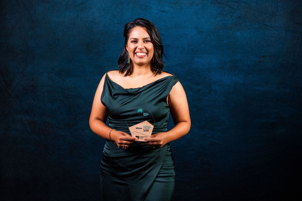 Portrait against dark blue backdrop in elegant evening wear.