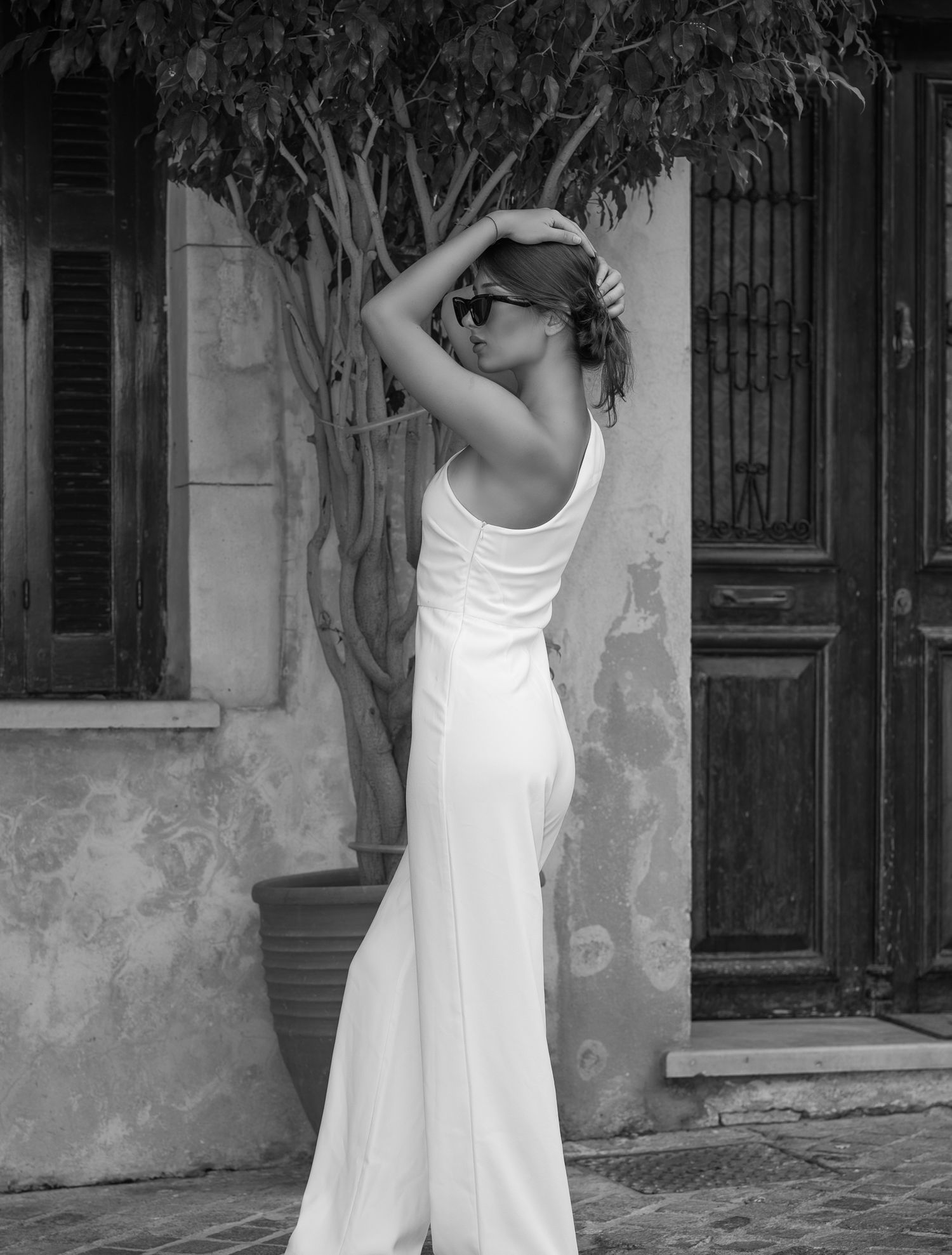 Fashion- and beautyfotografie - Artistic black and white photo of woman in white dress against vintage building.
