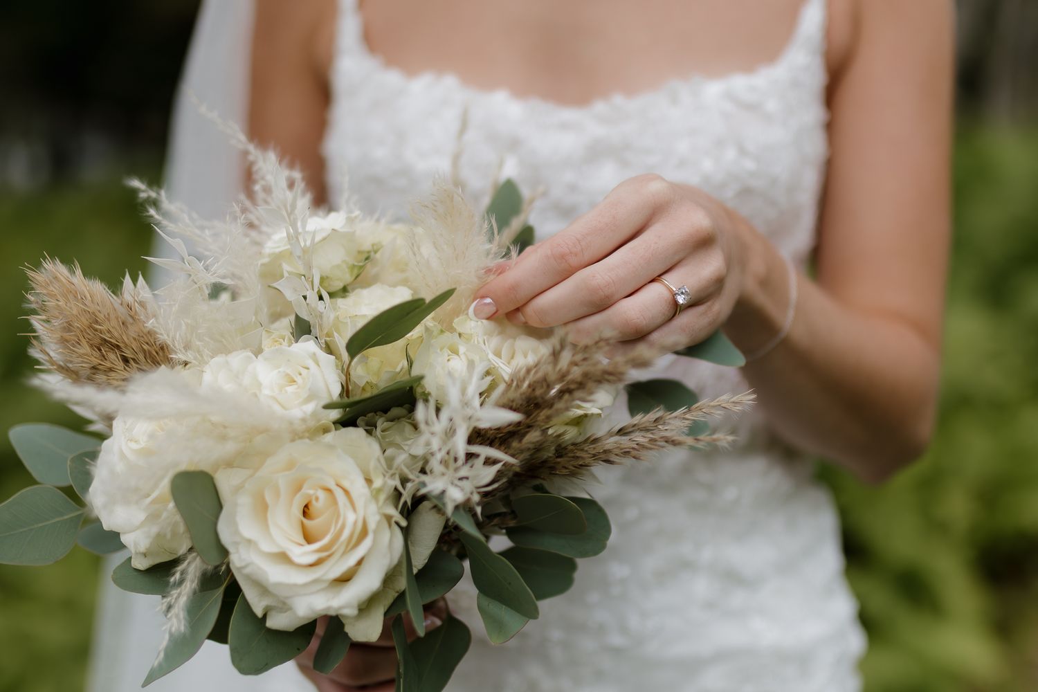 An elegant bridal bouquet with white roses, dried flowers and eucalyptus leaves.